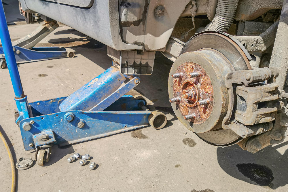 Levantando um carro para trocar um pneu substituindo a roda do carro usando o macaco hidráulico.